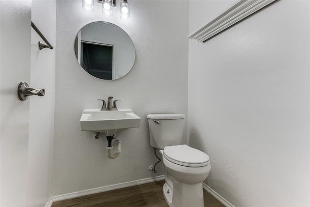 bathroom with hardwood / wood-style flooring, sink, and toilet