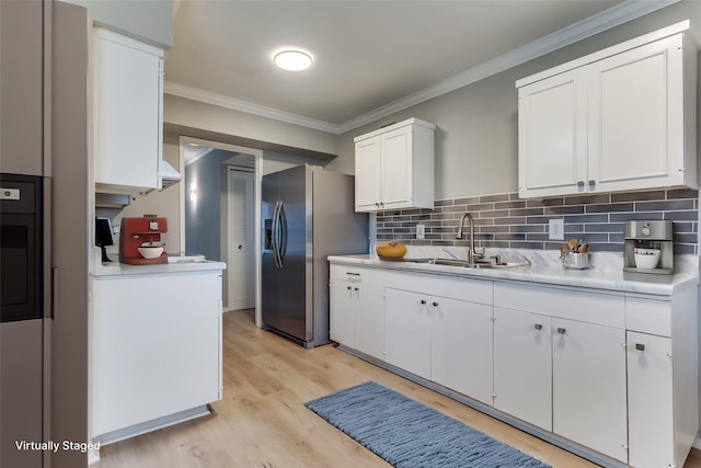 kitchen featuring white cabinetry, sink, crown molding, stainless steel refrigerator with ice dispenser, and light wood-type flooring