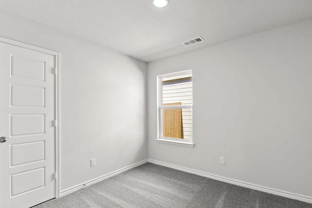 carpeted empty room with visible vents and baseboards