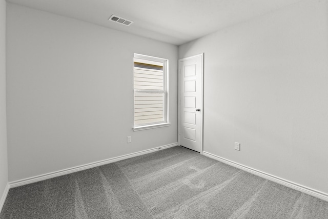 carpeted spare room with baseboards and visible vents