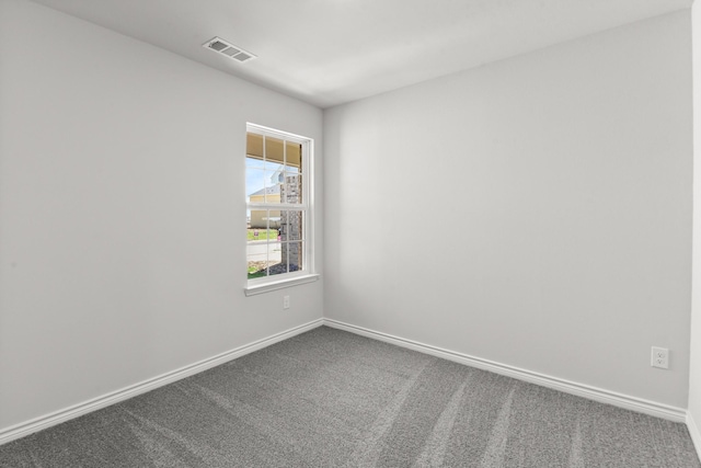 carpeted spare room with baseboards and visible vents