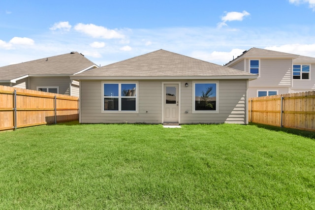 back of property featuring a fenced backyard, a lawn, and roof with shingles