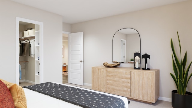 bedroom with baseboards and a walk in closet