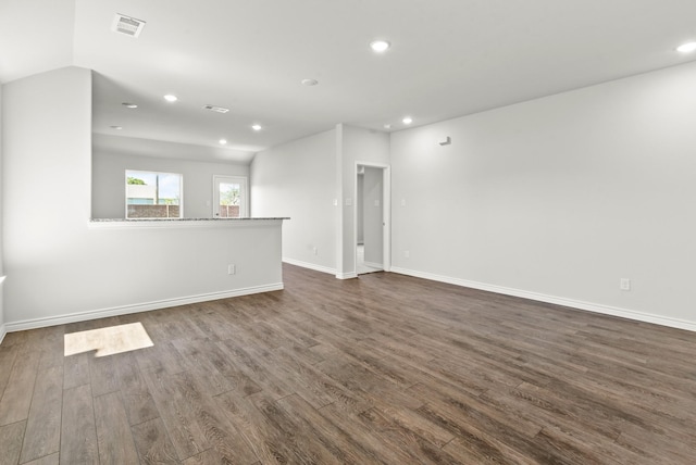 unfurnished living room with dark wood-type flooring and vaulted ceiling