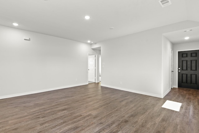 empty room with baseboards, visible vents, dark wood-style flooring, and recessed lighting