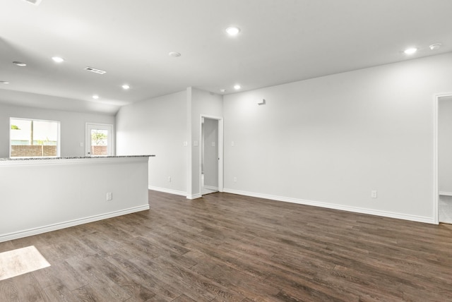 empty room featuring baseboards, dark wood-style flooring, and recessed lighting