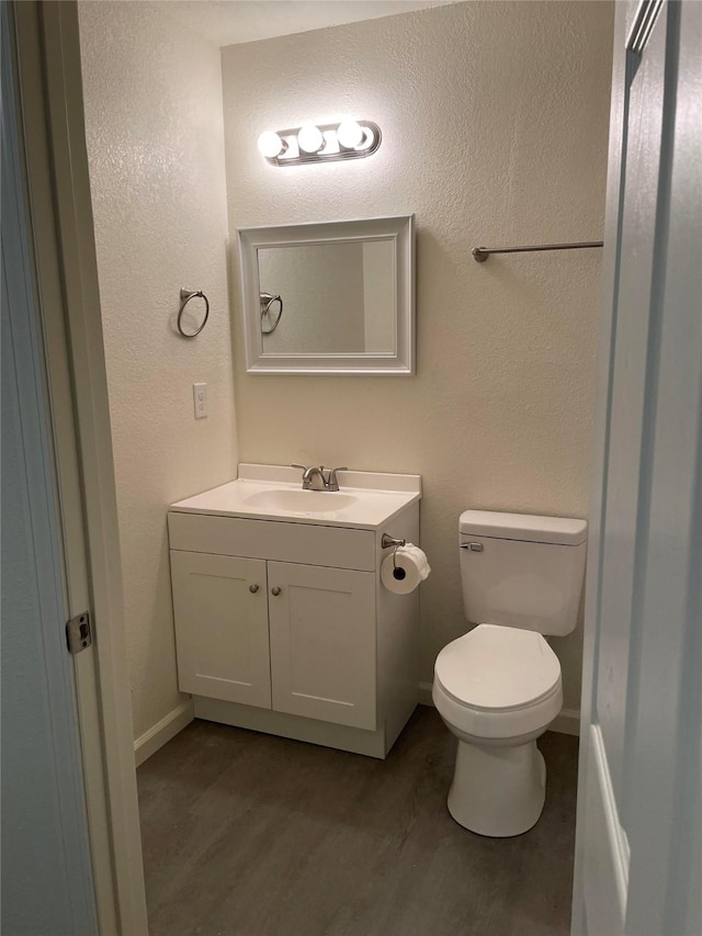 bathroom featuring vanity, toilet, and hardwood / wood-style floors