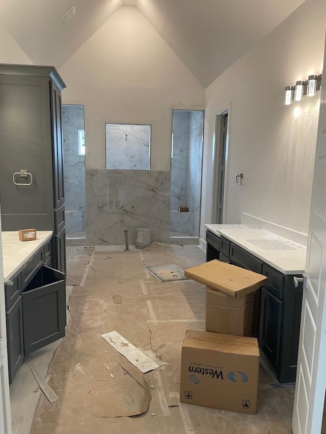 full bath with vaulted ceiling and a marble finish shower