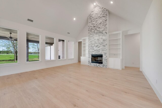 unfurnished living room featuring visible vents, built in features, ceiling fan, light wood-style floors, and a fireplace