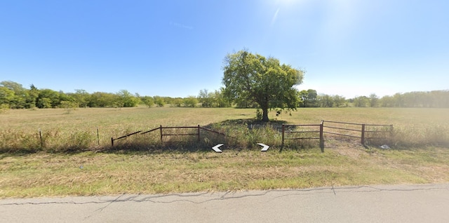 view of yard featuring a rural view and fence