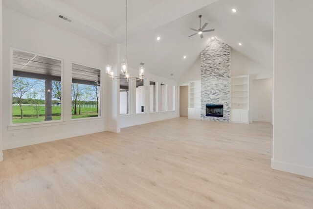unfurnished living room with ceiling fan with notable chandelier, built in features, a fireplace, light wood-style flooring, and visible vents