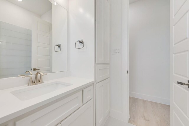 bathroom featuring vanity, baseboards, and wood finished floors