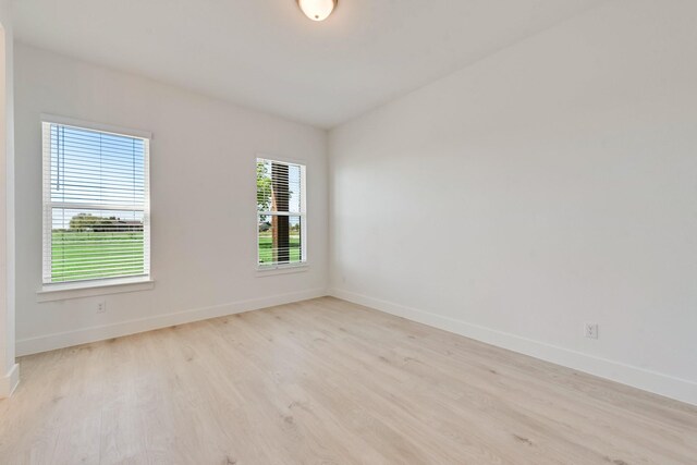 empty room featuring baseboards and wood finished floors