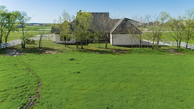 view of yard with fence and a rural view