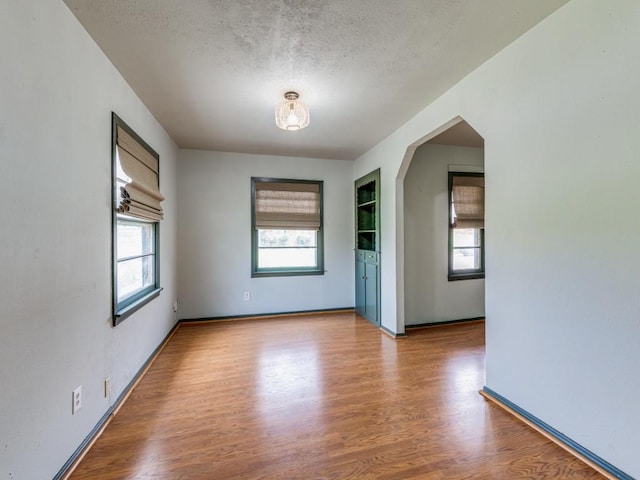 empty room featuring a textured ceiling and light hardwood / wood-style floors