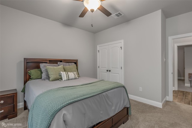 carpeted bedroom featuring ceiling fan and a closet