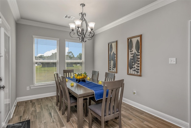 dining room with crown molding, hardwood / wood-style floors, and a notable chandelier