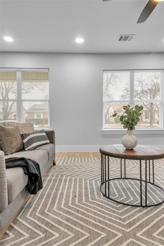 living room featuring ceiling fan, plenty of natural light, and wood-type flooring