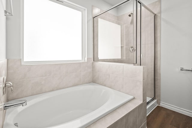 bathroom with wood-type flooring and independent shower and bath