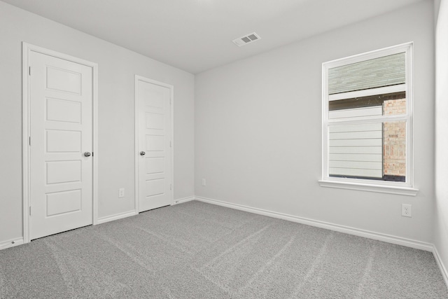 unfurnished bedroom featuring multiple windows and carpet