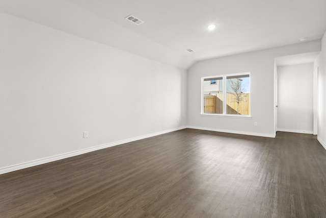 spare room with lofted ceiling and dark hardwood / wood-style flooring