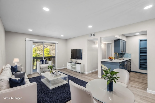 living room with sink and light hardwood / wood-style flooring