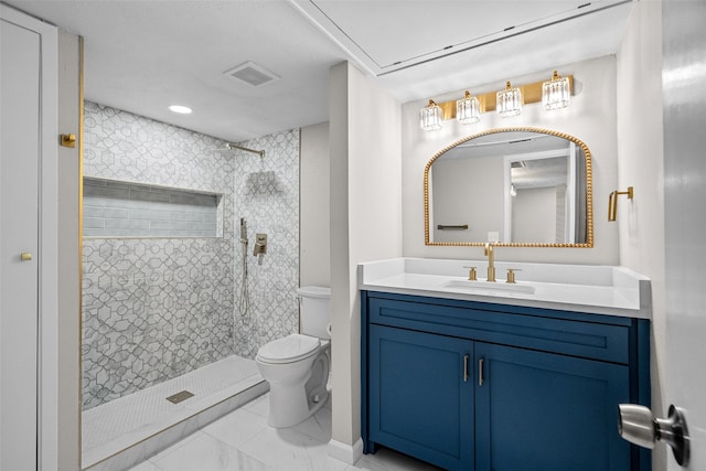 bathroom featuring tiled shower, vanity, and toilet