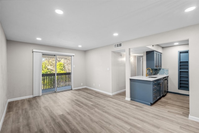 kitchen featuring dishwasher, sink, and light hardwood / wood-style floors