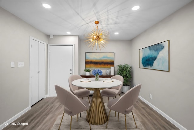 dining area with an inviting chandelier and hardwood / wood-style flooring