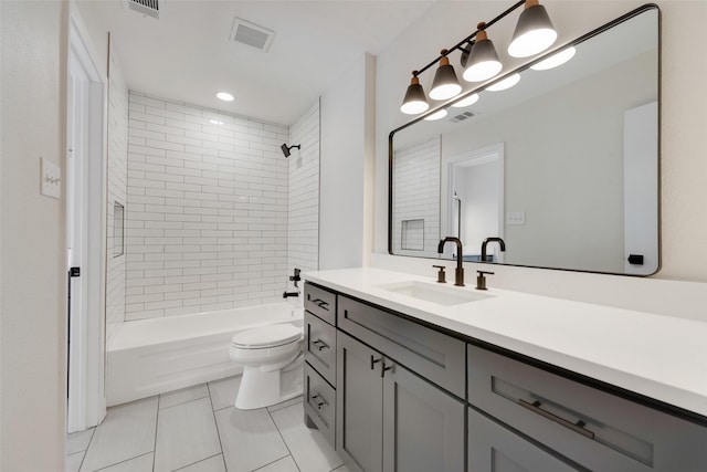 full bathroom with tile patterned flooring, tiled shower / bath, vanity, and toilet