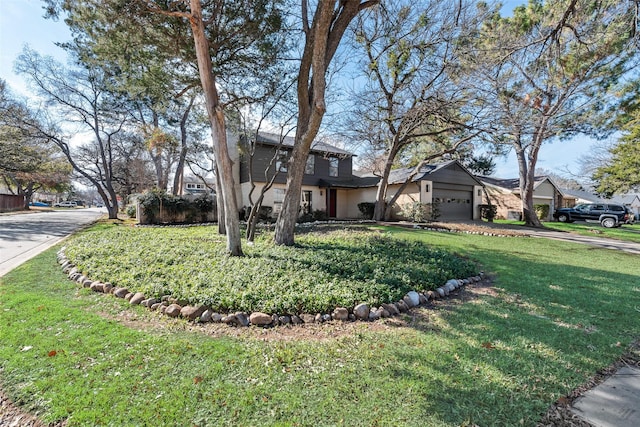 view of front of property featuring a garage and a front lawn