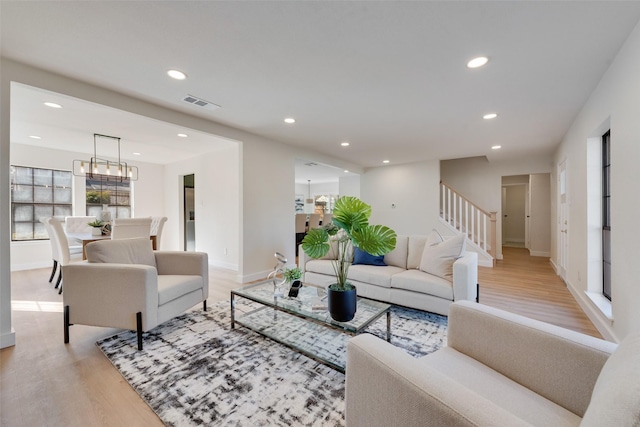 living room with a chandelier and light wood-type flooring