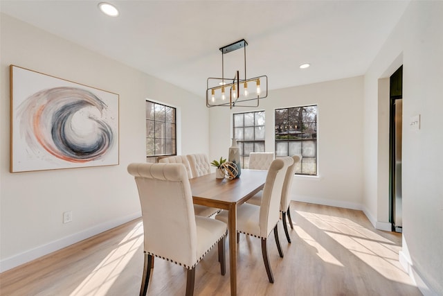 dining room with an inviting chandelier and light hardwood / wood-style flooring