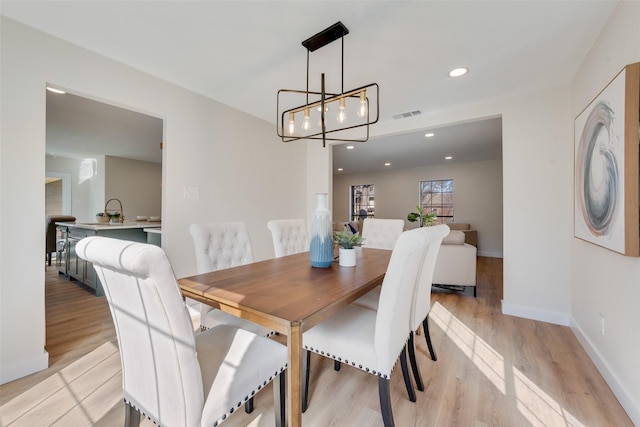 dining area featuring a notable chandelier and light hardwood / wood-style floors