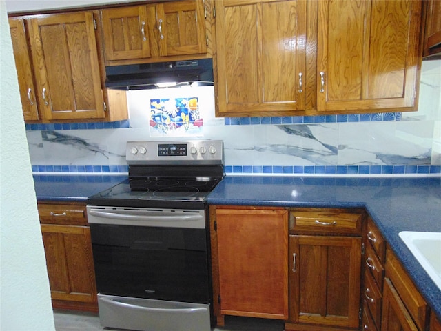 kitchen featuring sink, backsplash, and stainless steel range with electric stovetop