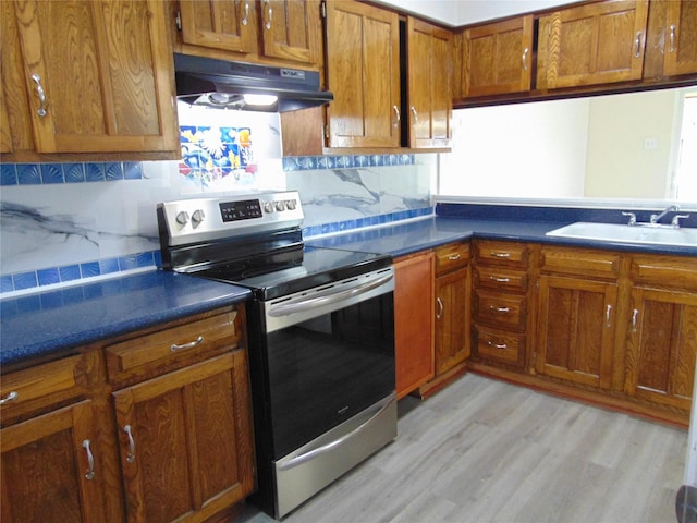 kitchen featuring tasteful backsplash, sink, electric range, and light wood-type flooring