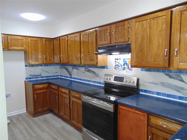 kitchen with backsplash, light hardwood / wood-style flooring, and stainless steel range with electric cooktop