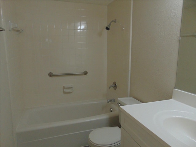 full bathroom featuring vanity, tiled shower / bath, and toilet