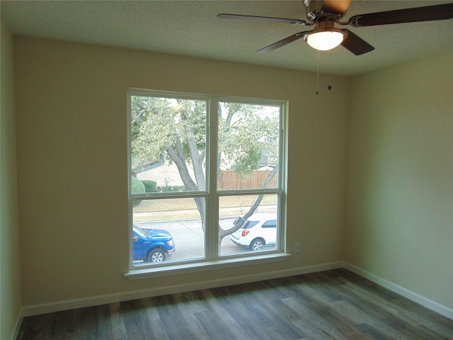 empty room with ceiling fan and dark hardwood / wood-style floors