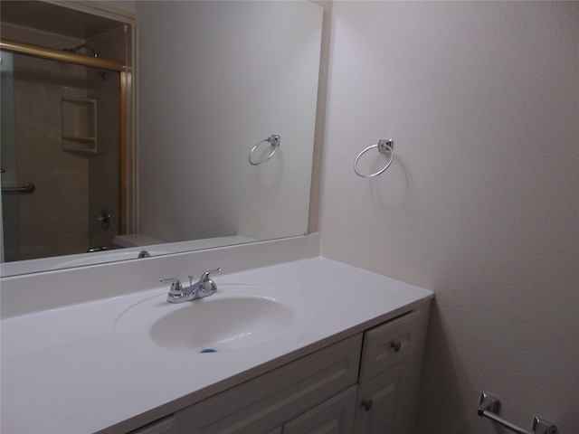 bathroom featuring walk in shower, vanity, and toilet