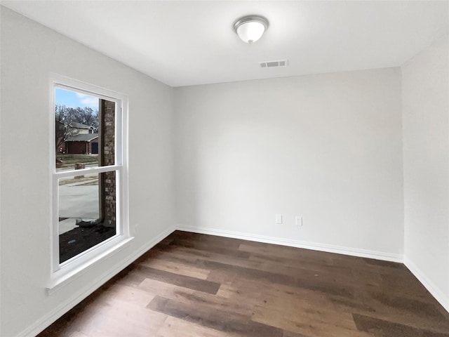 unfurnished room with dark hardwood / wood-style flooring