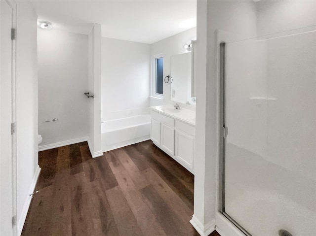 full bathroom featuring hardwood / wood-style flooring, vanity, shower with separate bathtub, and toilet