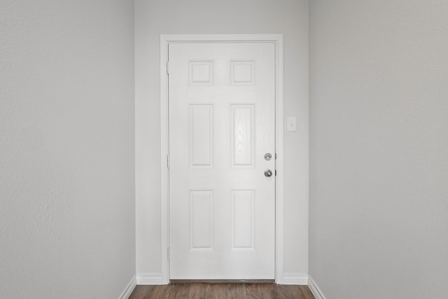 doorway to outside with dark wood-style flooring and baseboards