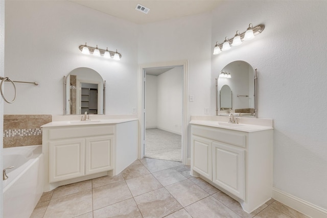 bathroom featuring tile patterned floors, a bathing tub, and vanity