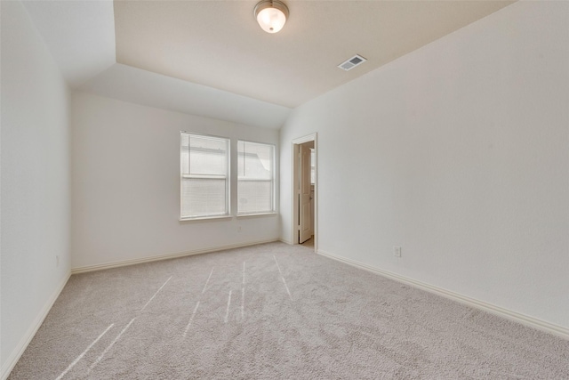 carpeted spare room featuring lofted ceiling