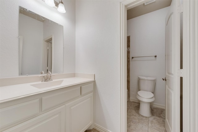 bathroom featuring vanity, tile patterned floors, and toilet