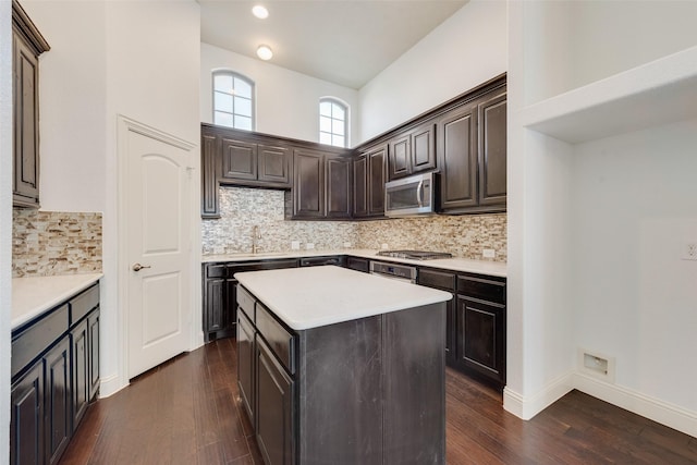 kitchen featuring tasteful backsplash, dark wood-type flooring, stainless steel appliances, and a center island