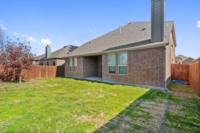 rear view of house with a patio area and a lawn