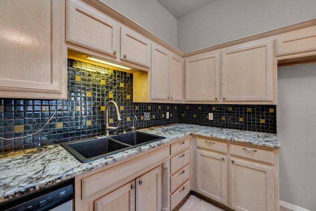 kitchen featuring light brown cabinetry, sink, light stone counters, stainless steel dishwasher, and decorative backsplash