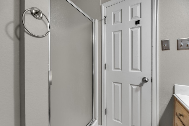 bathroom with walk in shower and vanity